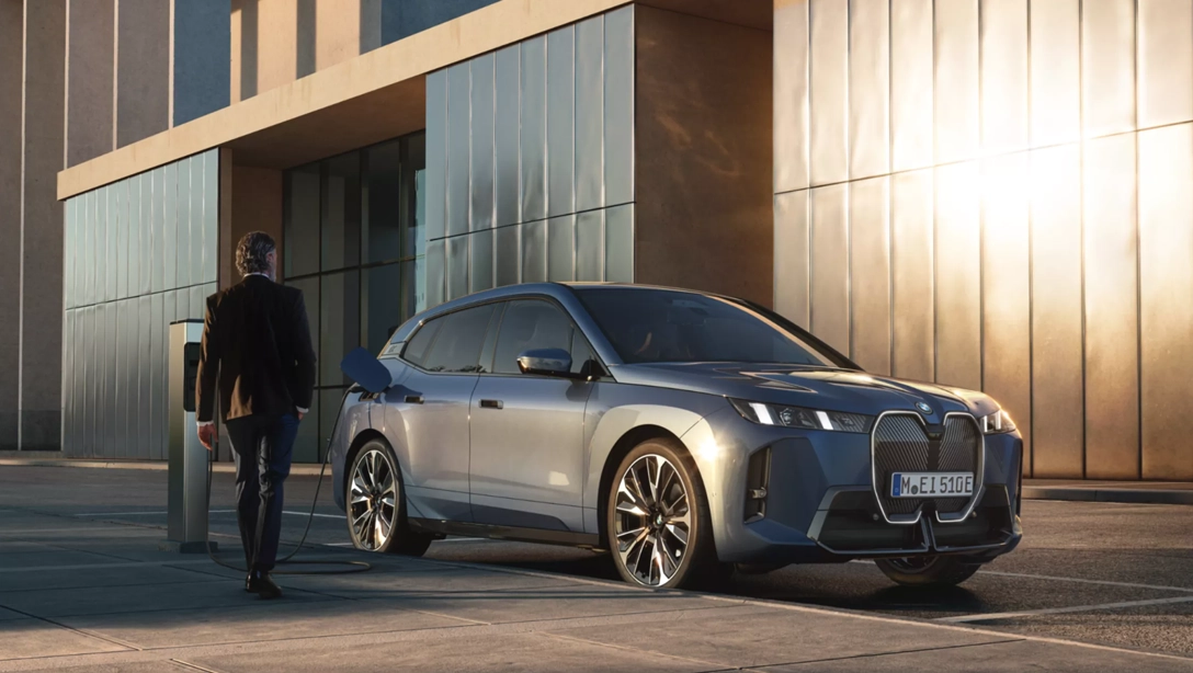 Vue avant du BMW iX électrique sur route, design moderne et imposant